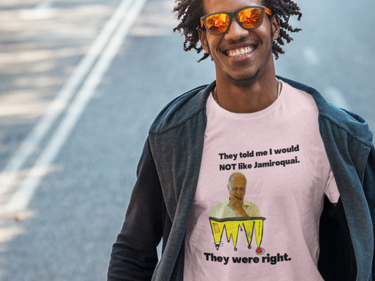 Smiling man wearing a pink t-shirt that says 'They told me I would NOT like Jamiroquai. They were right.' with a puzzled older man and a colorful abstract graphic illustration.