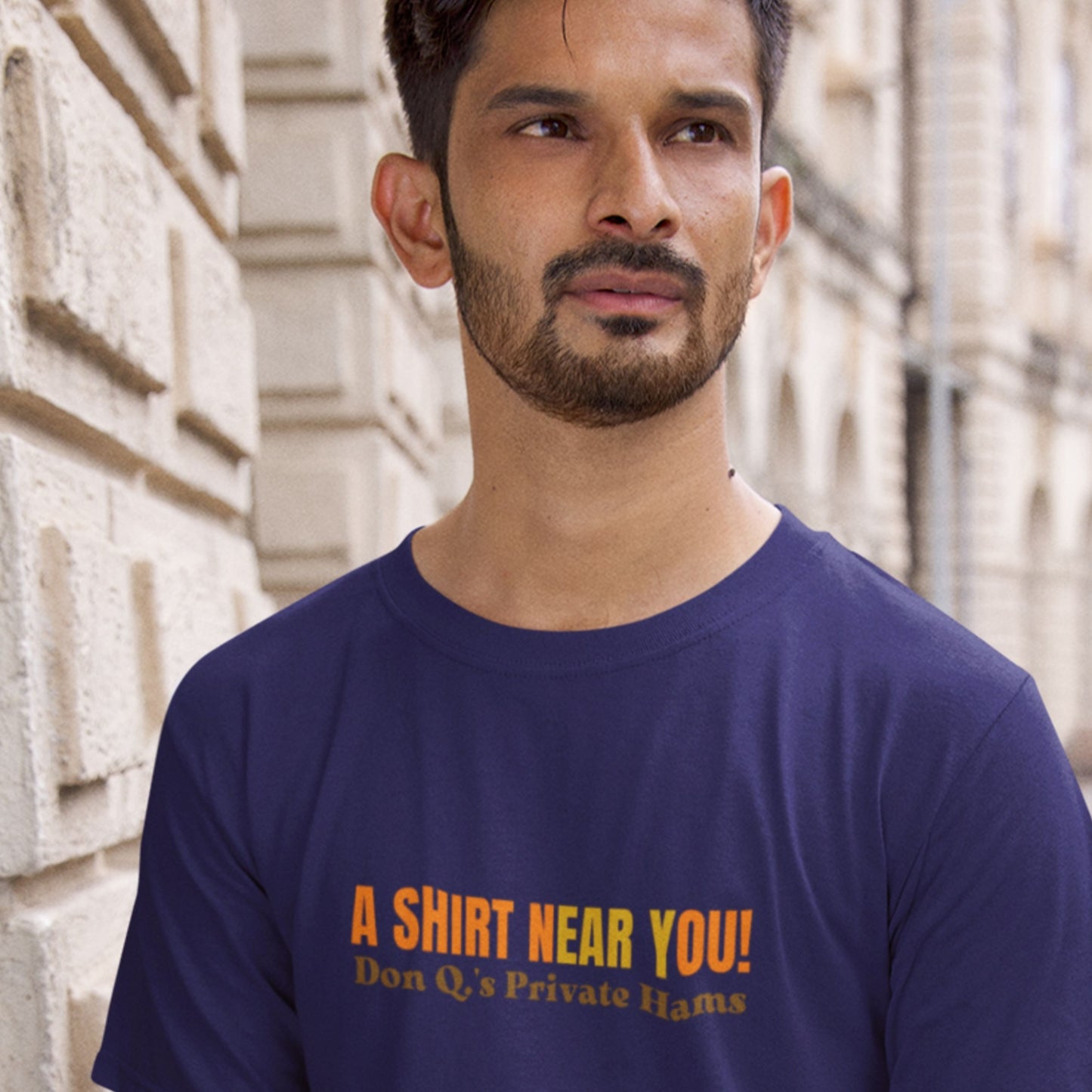 Man in Europe wearing a navy Black t-shirt with multicolored 'A shirt near you!' text outside.