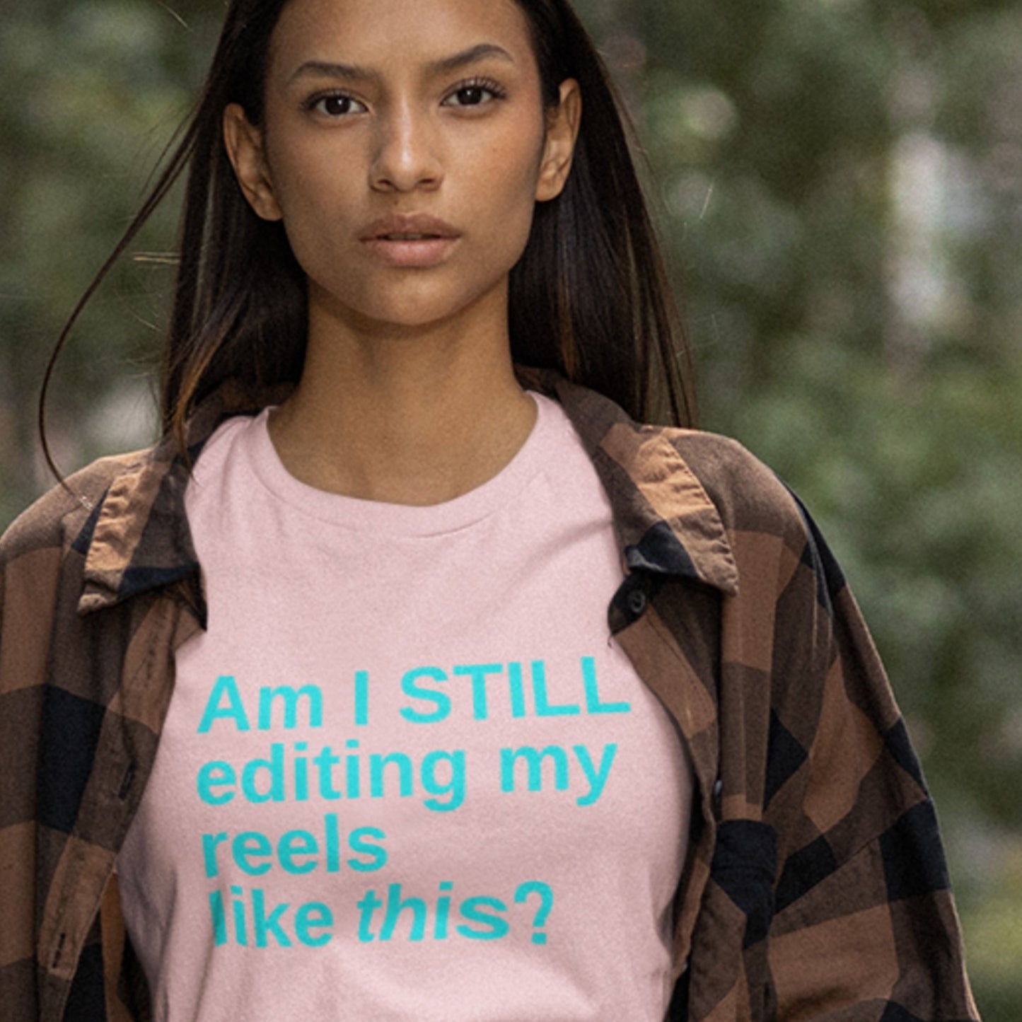 Person wearing a pink t-shirt with text outdoors.