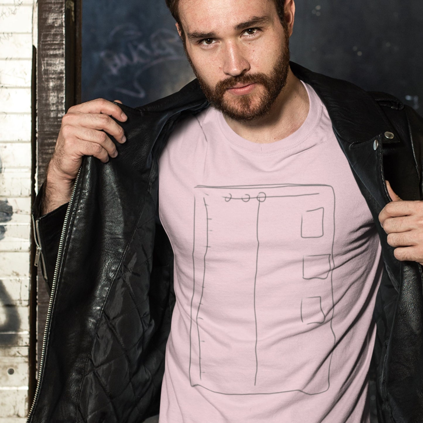 Man wearing a pink t-shirt with a colorful abstract drawing in front of a house.