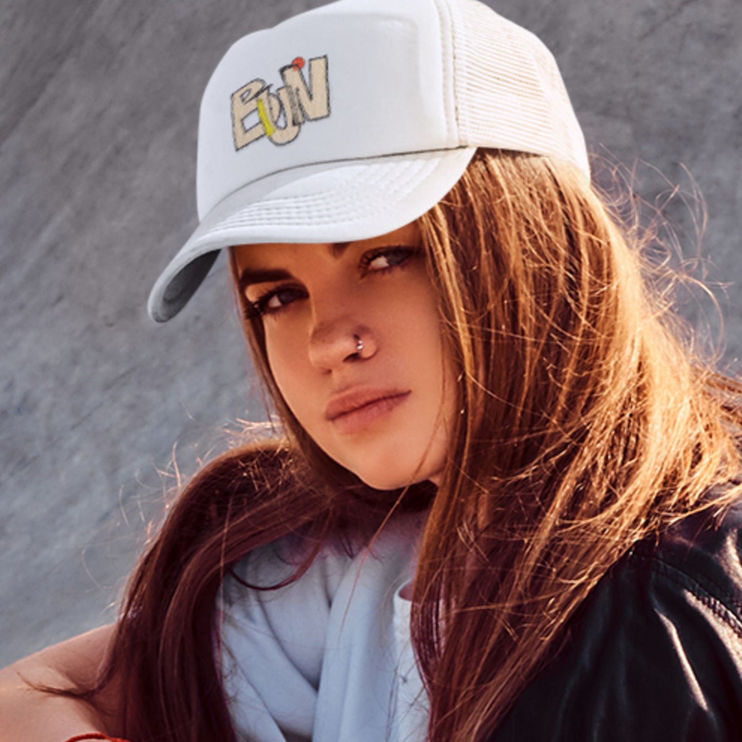 Person wearing a white cap with 'BUN' text against a gray background.