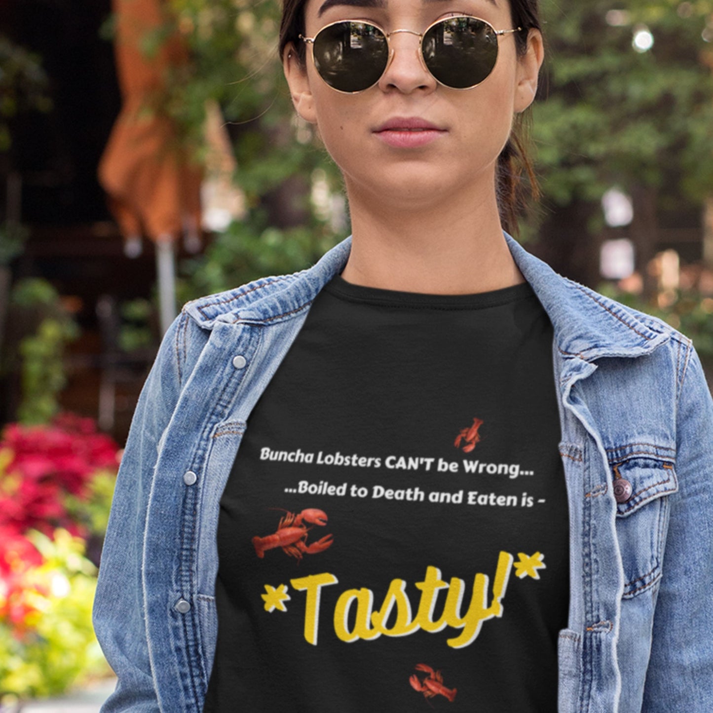 Person wearing a black t-shirt with a humorous lobster-themed message, outdoors.