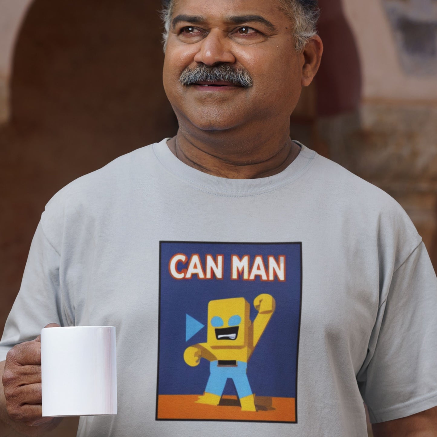 Man wearing a t-shirt with 'CAN MAN' graphic design, holding a mug.