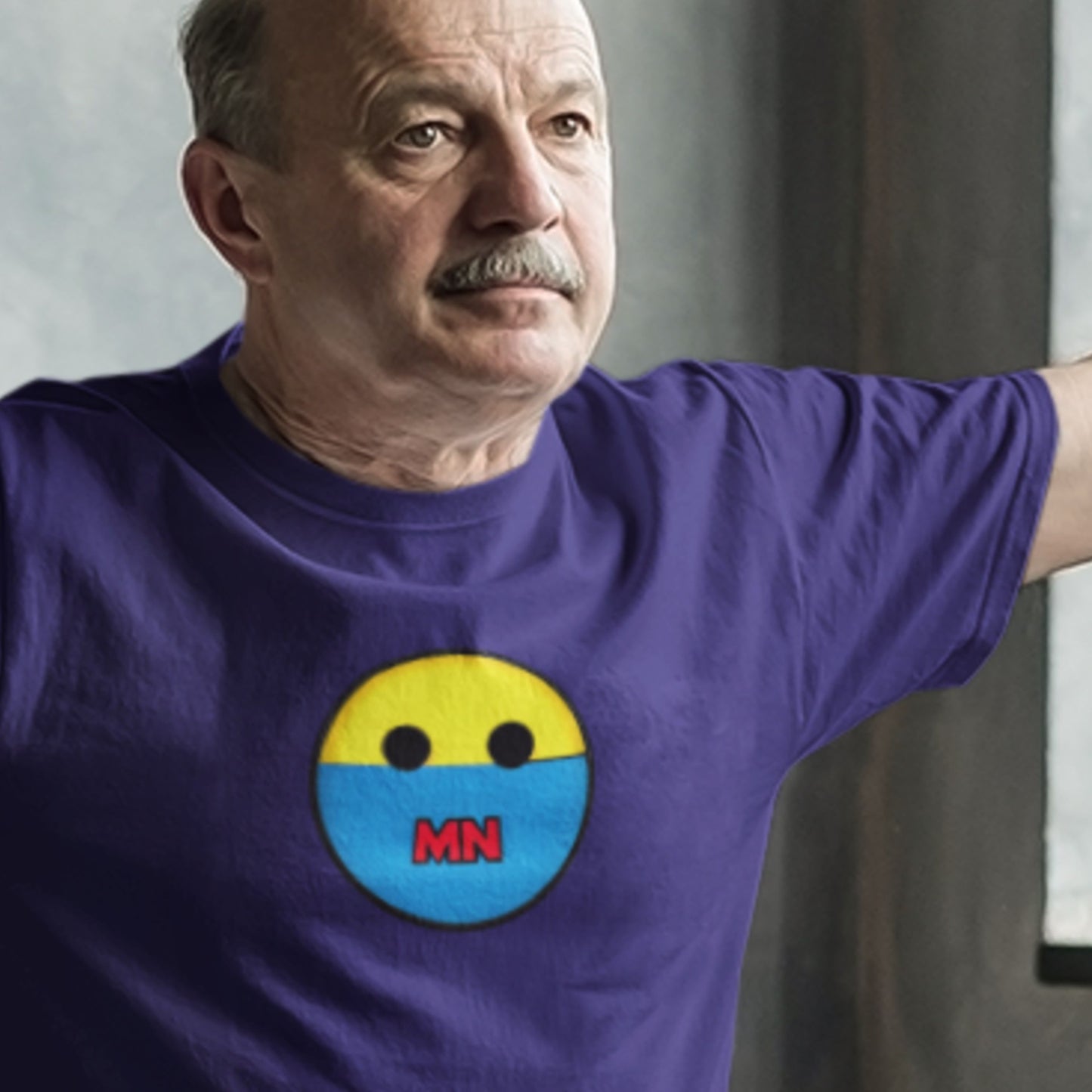 Man wearing a purple t-shirt with a smiley face design featuring 'MN'.