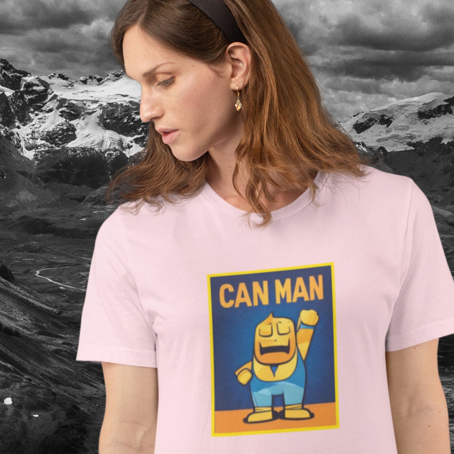 Woman wearing a pink t-shirt with a colorful cartoon illustration in the mountains.