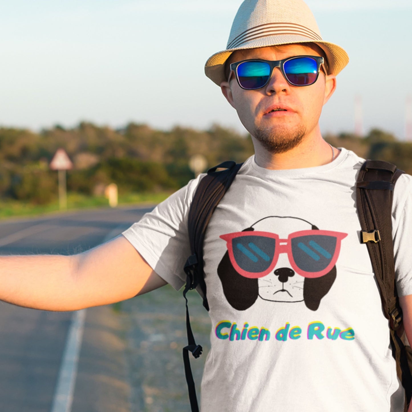 Man wearing a white t-shirt with a dog graphic and 'Chien de Rue' text, standing on a road.