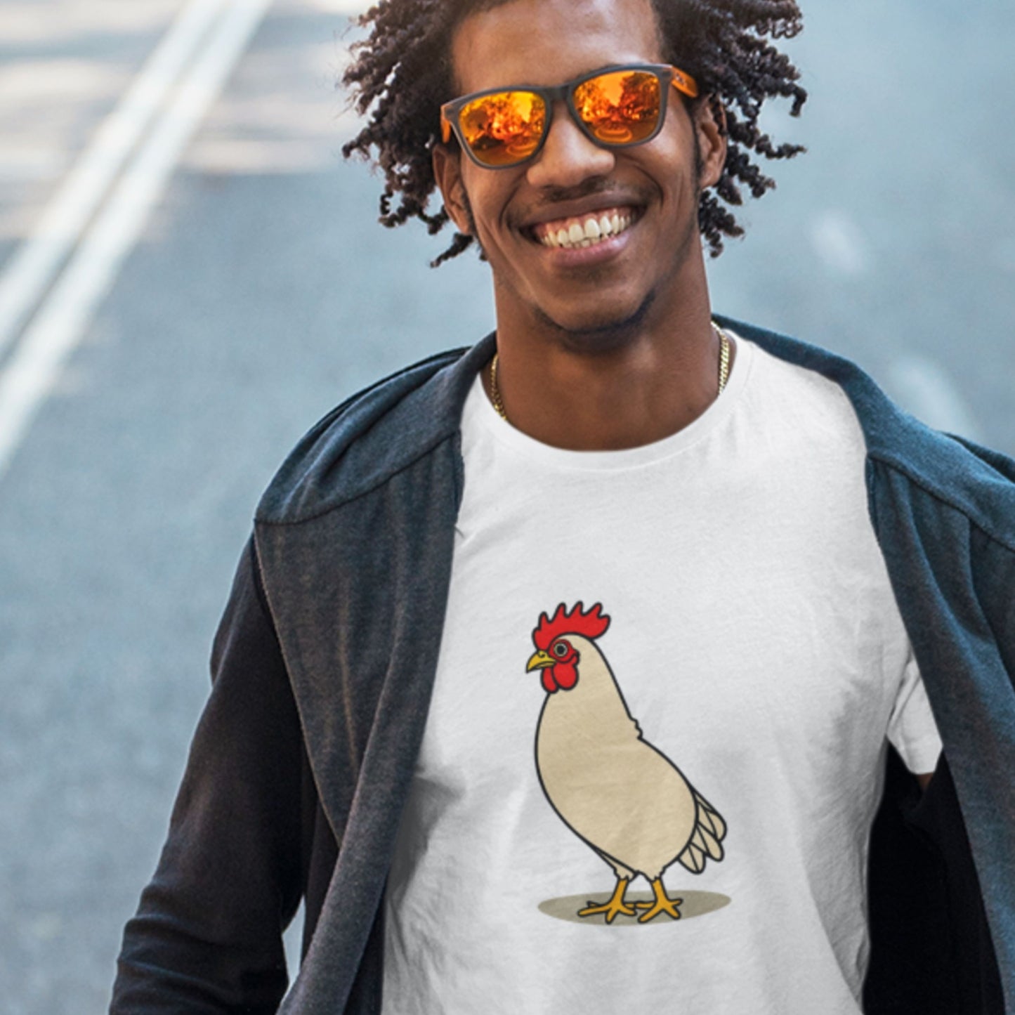 Man wearing a white t-shirt with a cartoon illustration of a rooster outside.
