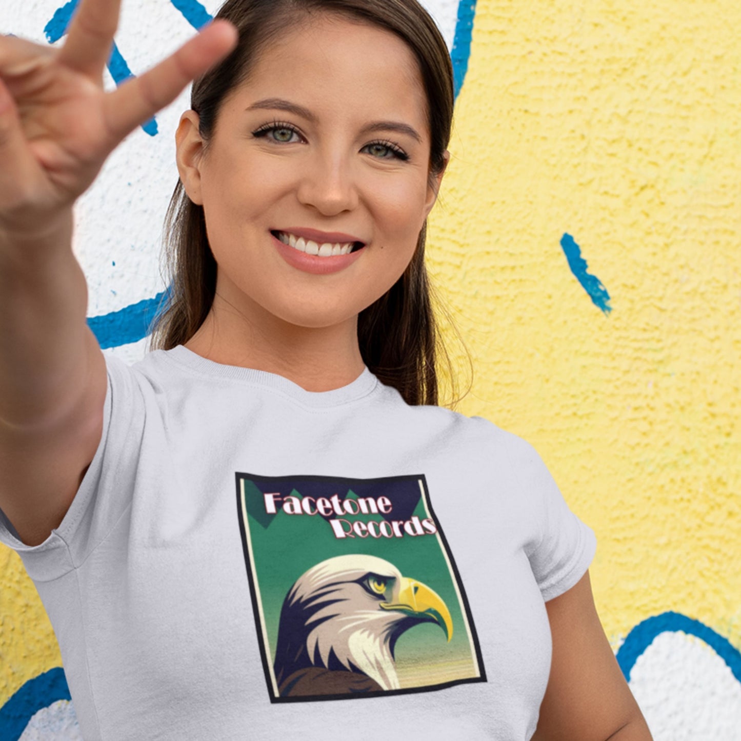 Woman wearing a white t-shirt with an eagle graphic and 'Facetone Records' text against a colorful background