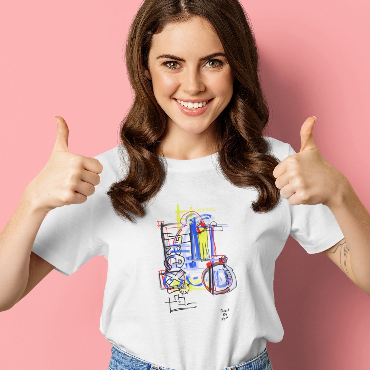 Thumbs up woman wearing a white t-shirt with a colorful abstract drawing on a pink background.