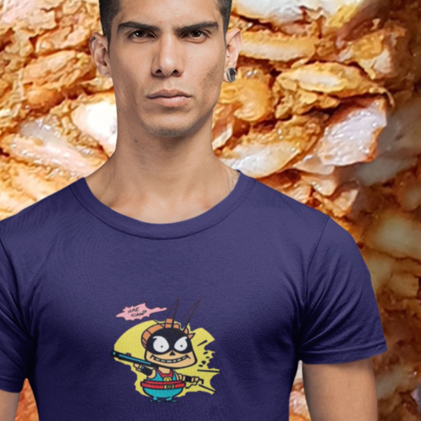 Scary man wearing a navy blue t-shirt with a fun, cartoon illustration in front of a giant gyro cone.
