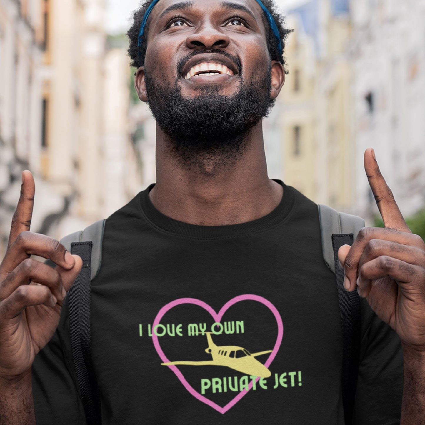 Man wearing a black t-shirt with a graphic design and text, standing outdoors.