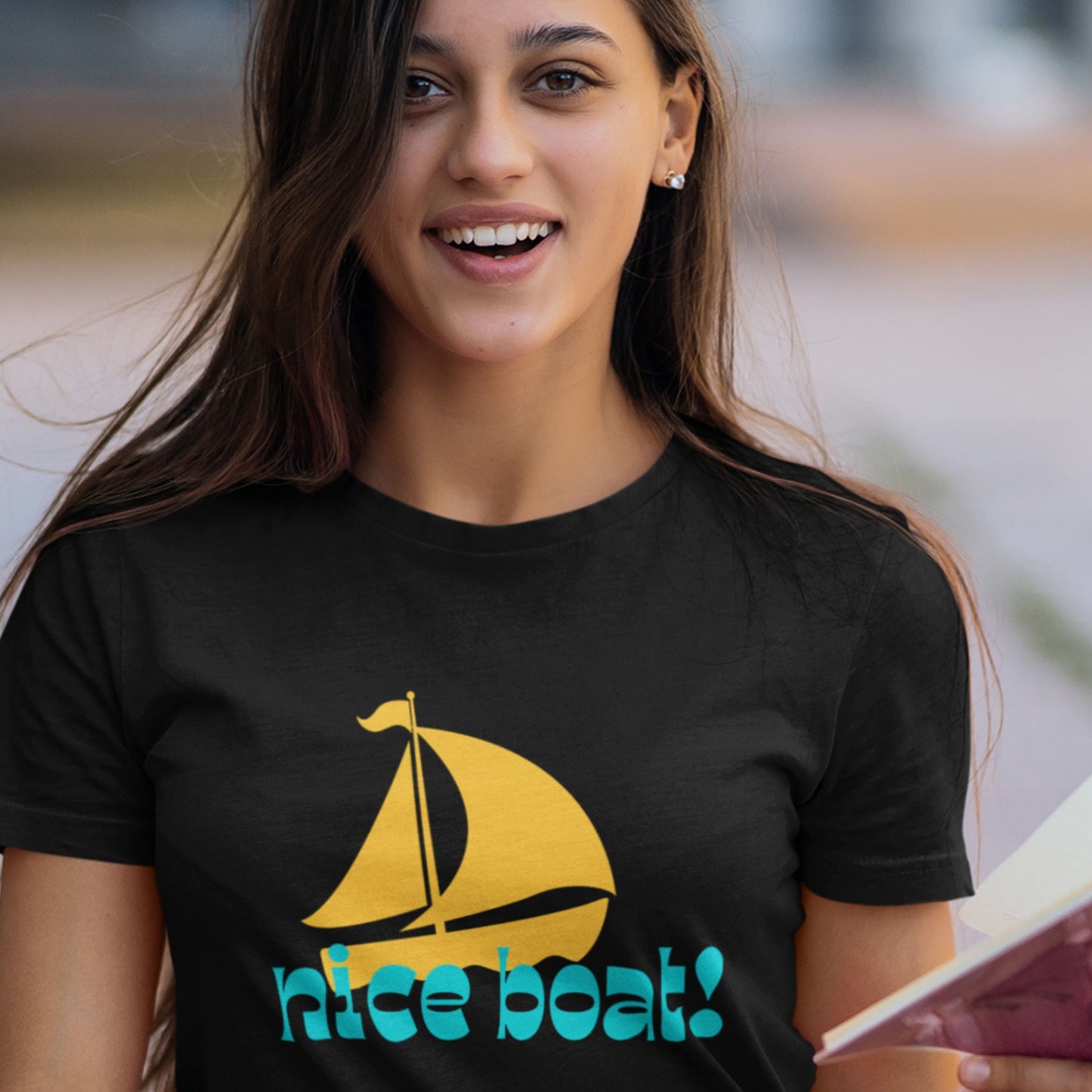 Woman wearing a black t-shirt with a yellow sailboat graphic and 'nice boat!' text.