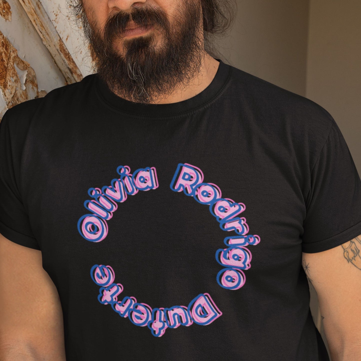 Man wearing a black t-shirt with multicolored 'Olivia Rodrigo Duterte' text outside.