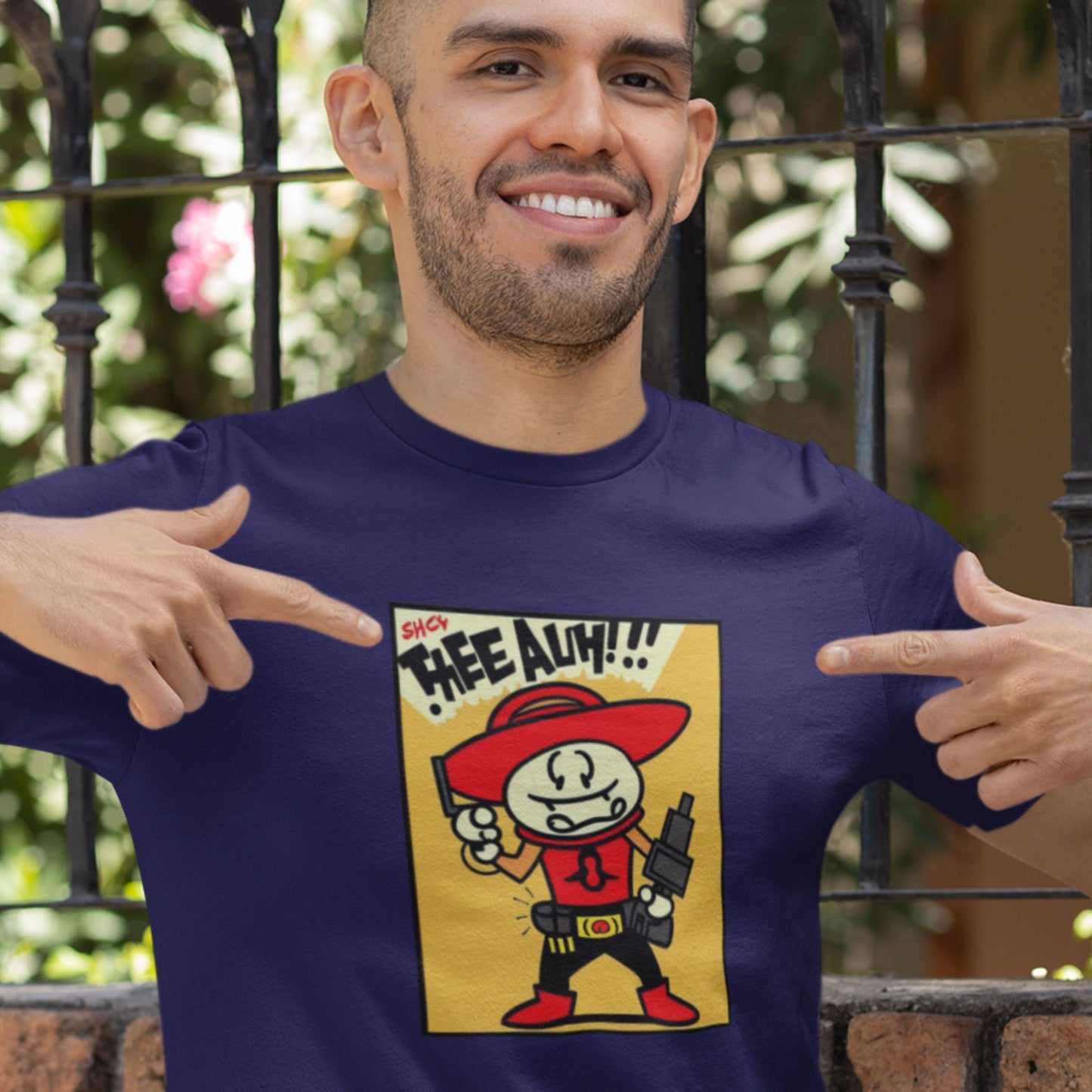 Man pointing to a graphic t-shirt with a cartoon character and text.