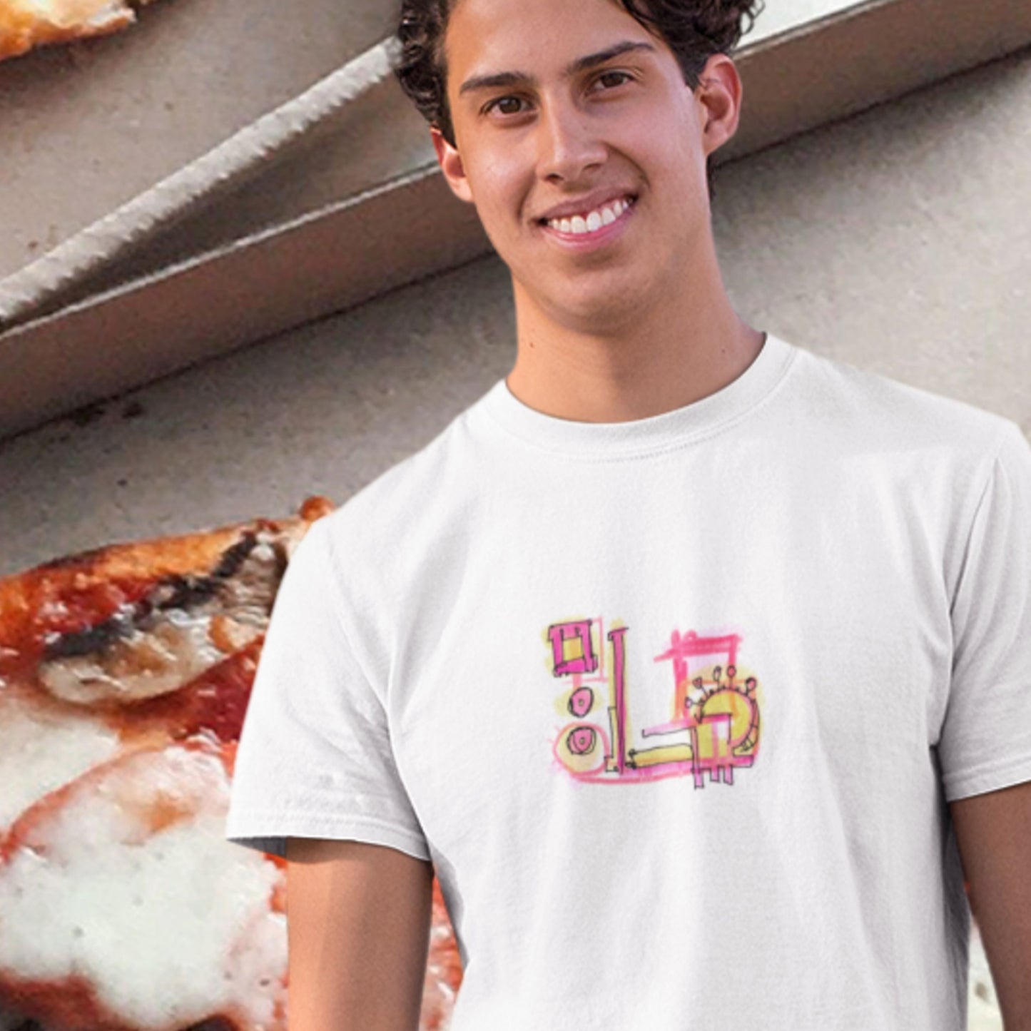 Man wearing a white t-shirt with a colorful abstract graffiti drawing in front of a giant pizza.
