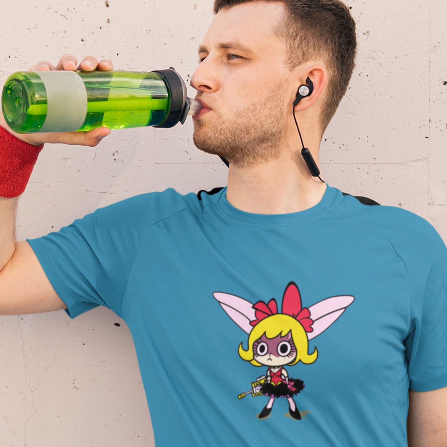 Man drinking a water bottle while wearing an aqua blue t-shirt with a fun, colorful cartoon illustration on a beige background.