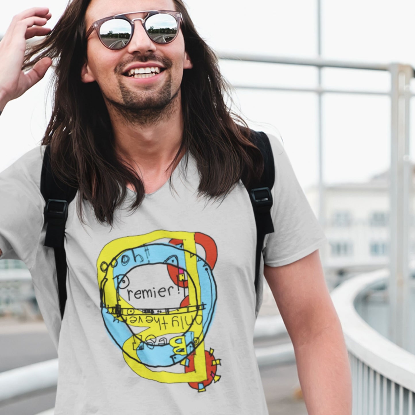 Man wearing a gray t-shirt with a colorful graphic design, standing outdoors.