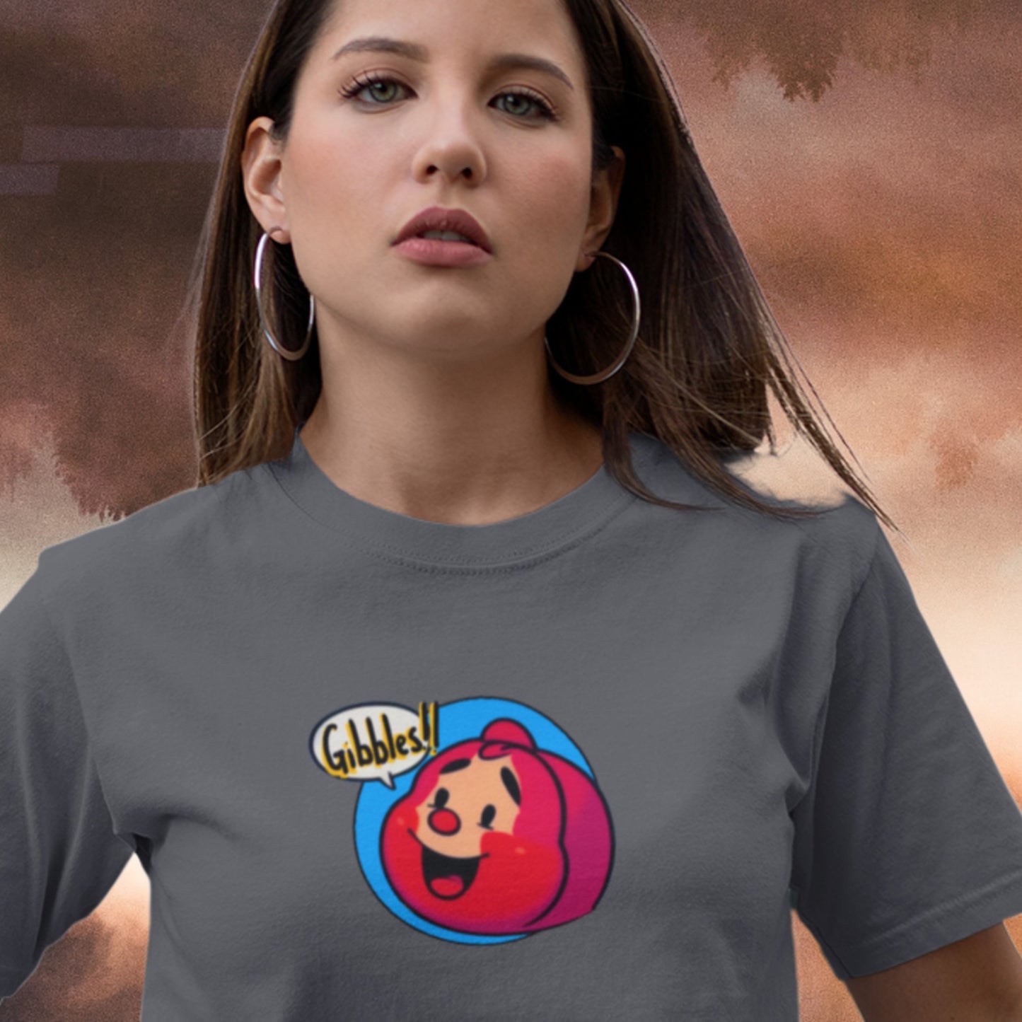 Woman wearing a dark grey t-shirt with a fun, colorful cartoon character illustration floats above the surface of the planet Jupiter.