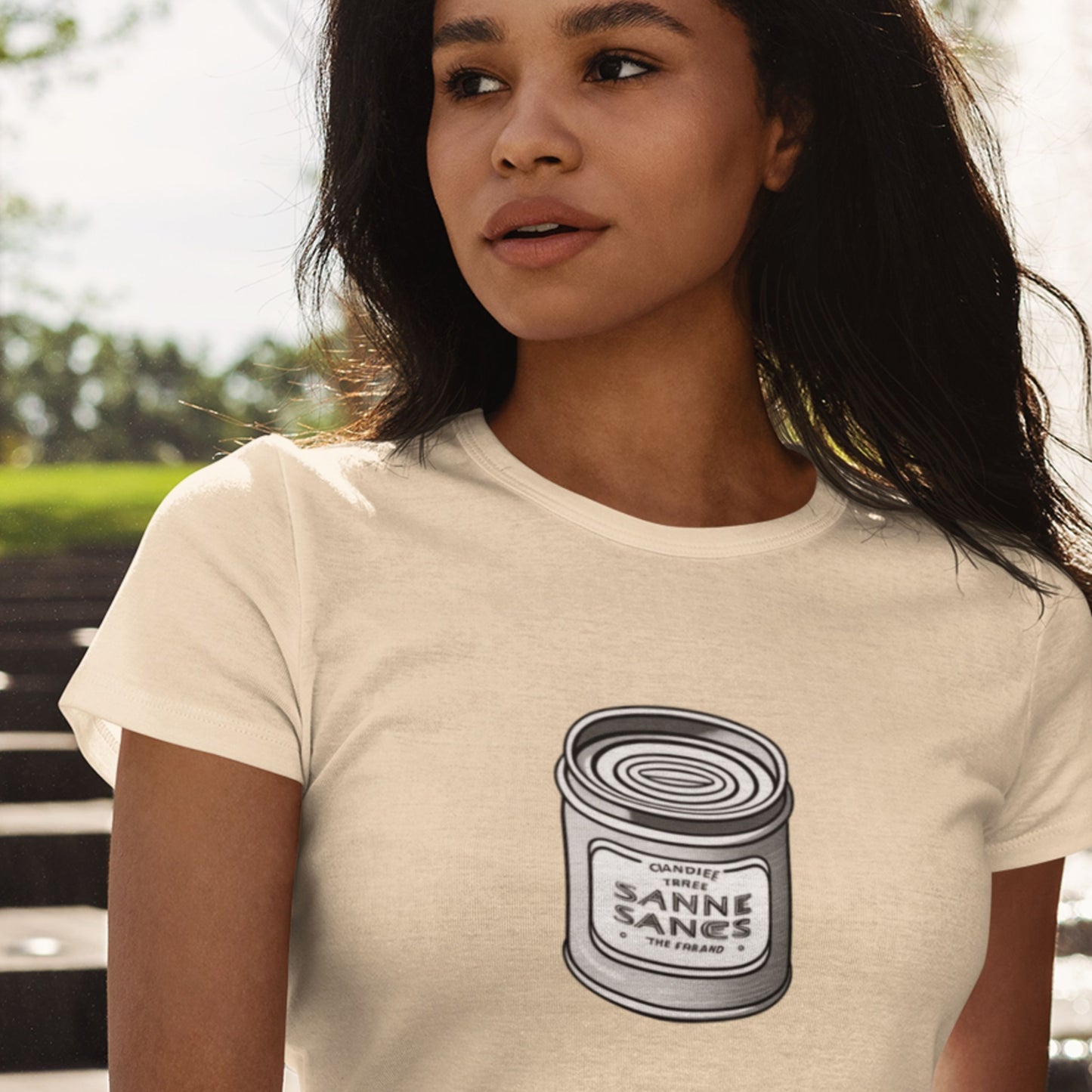 Woman wearing a beige t-shirt with a graphic design of a can labeled 'Sanne Sanes'.