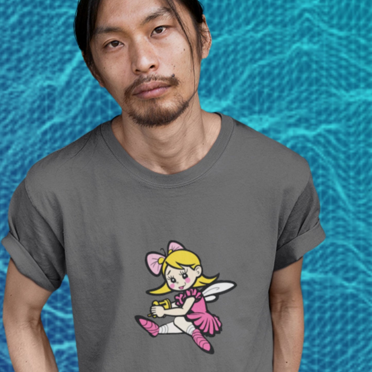 Man wearing a dark grey t-shirt with a fun, colorful cartoon fairy illustration in front of a pool.