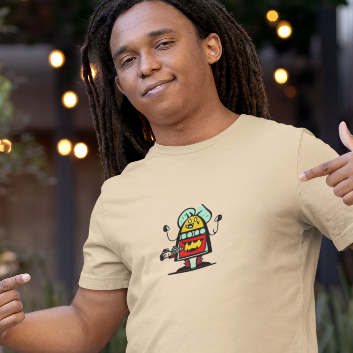 Man wearing a beige shirt with a fun, colorful cartoon alien illustration outside of a restaurant.