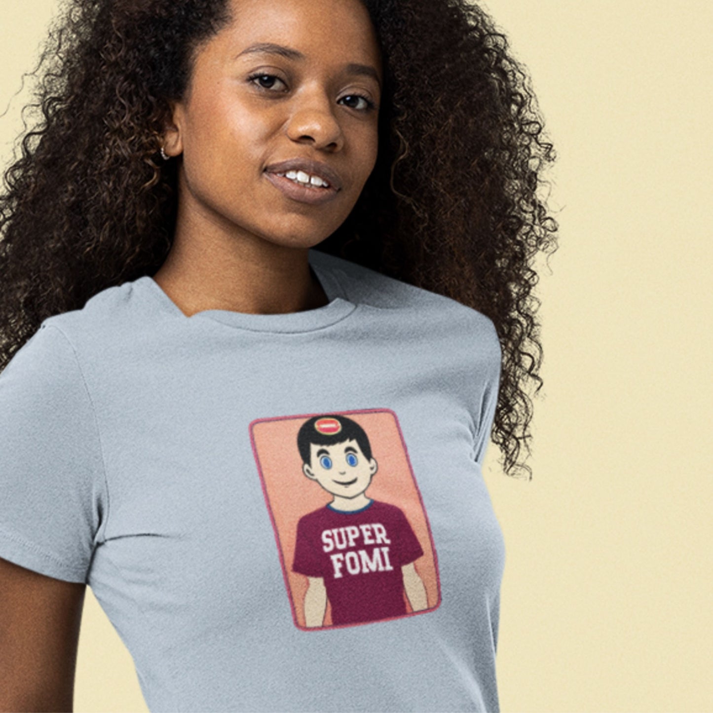 Woman wearing a light blue shirt with a fun, colorful cartoon illustration on a beige background.