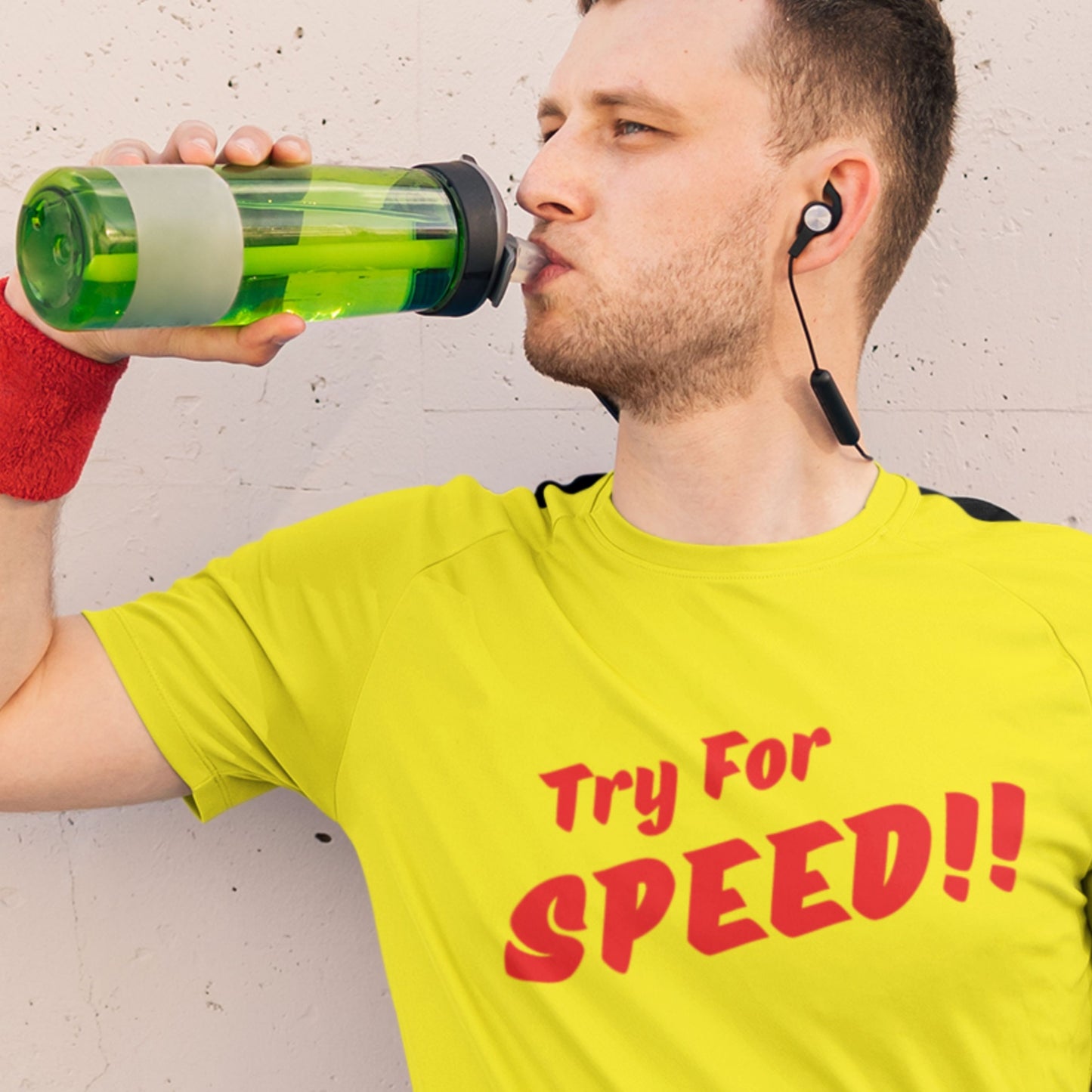 Man in a yellow shirt with 'Try For SPEED!!' text drinking from a green bottle.