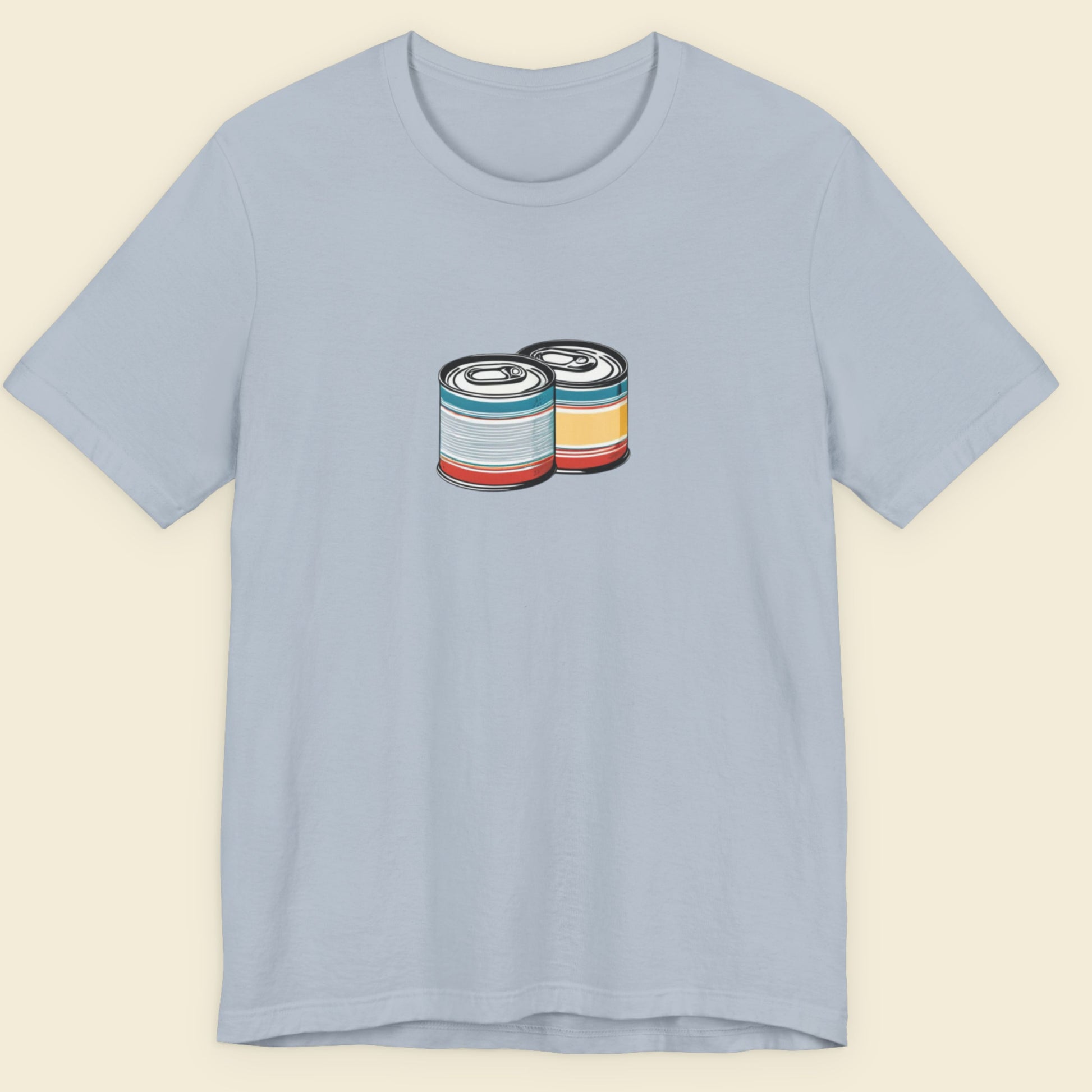 Light blue t-shirt with a drawing of 2 colorful cans on a beige background.