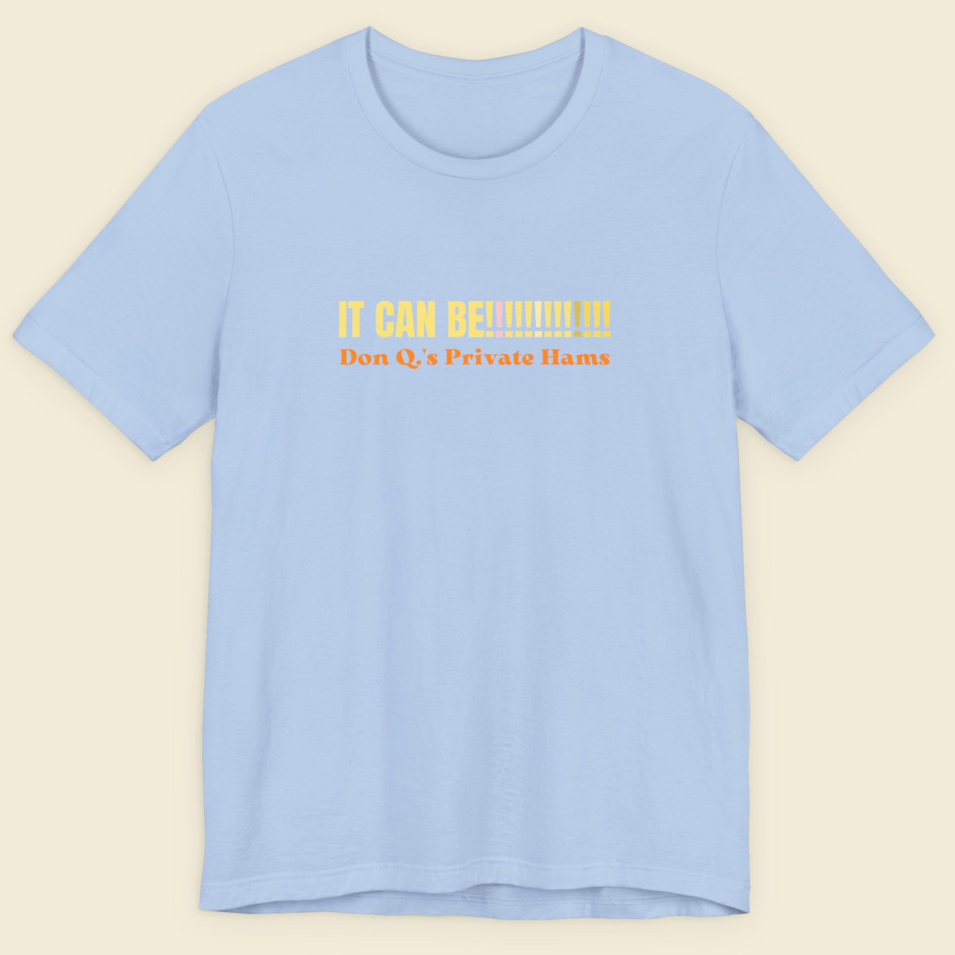 Light blue t-shirt with yellow text on a beige background.