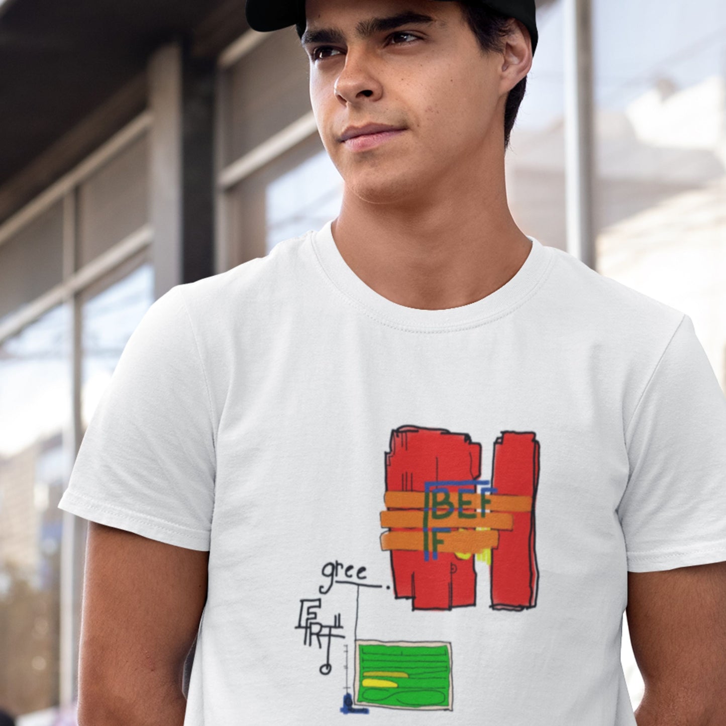 Man wearing a white t-shirt with a colorful 'BEFF' abstract drawing outside of a train station.