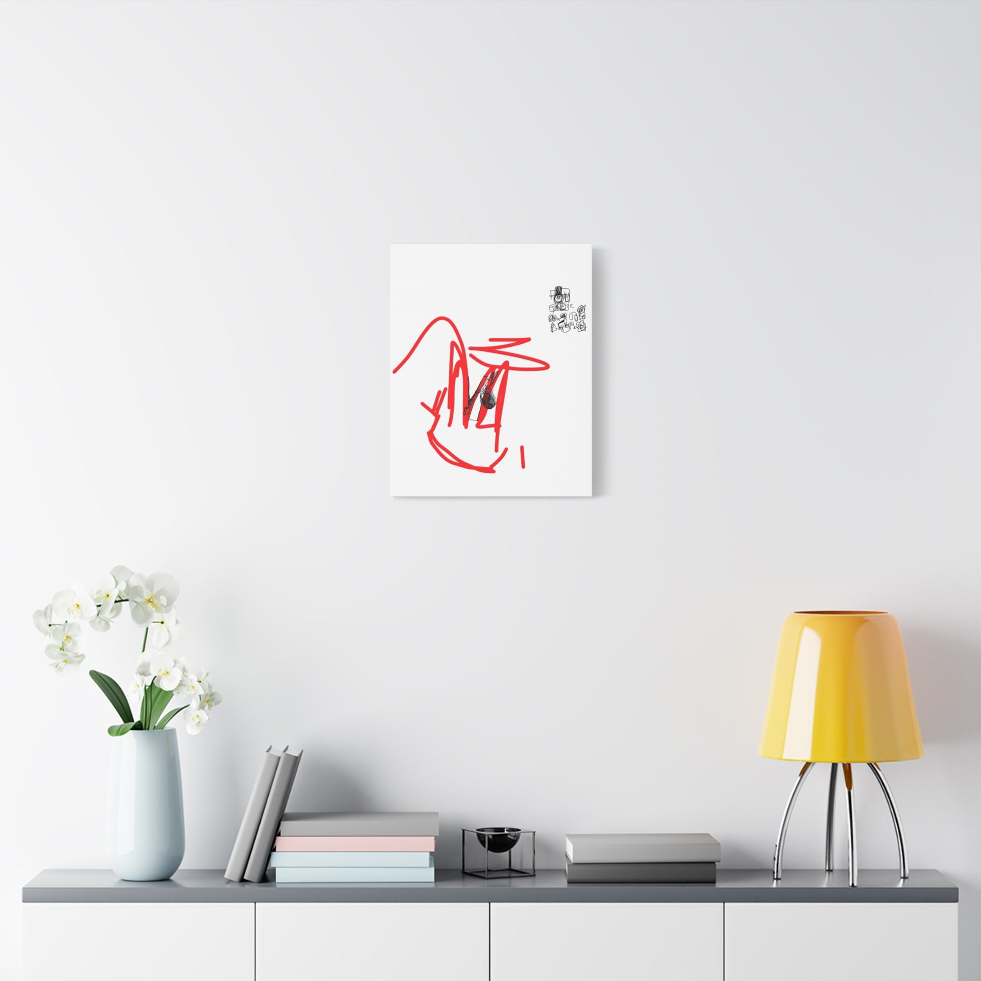 Framed artwork with red abstract design on a white wall above a shelf with decor items.