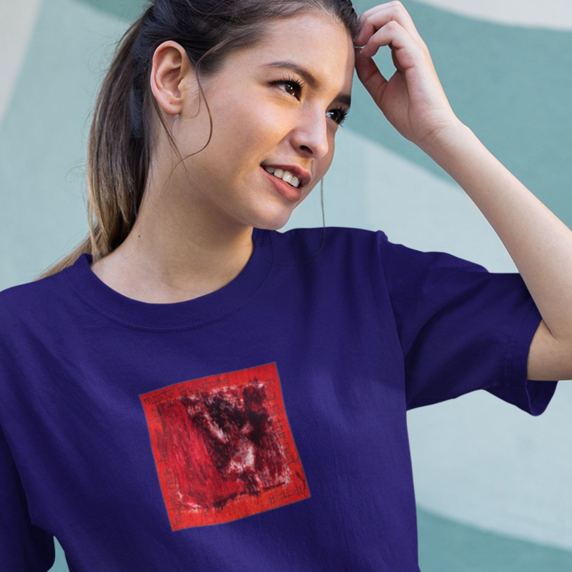 Woman wearing a purple t-shirt with a red graphic design on a light blue background
