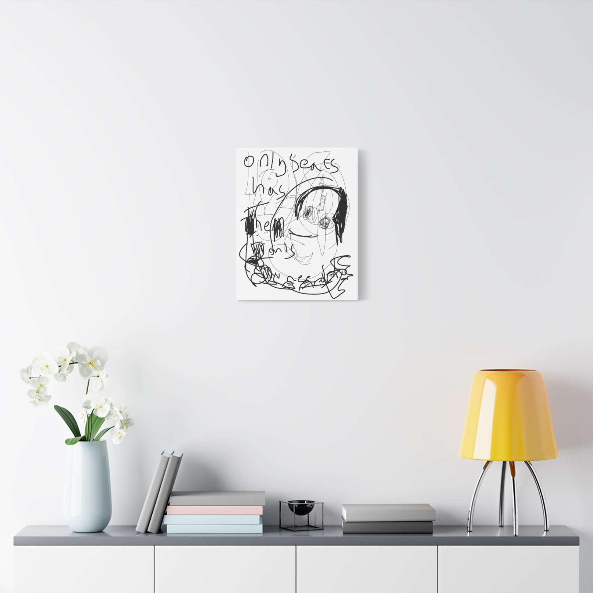 Framed artwork on a wall above a shelf with decor items