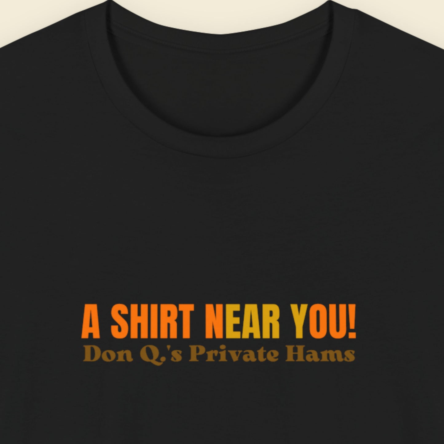 Black t-shirt with multicolored 'A shirt near you!' text on a beige background.