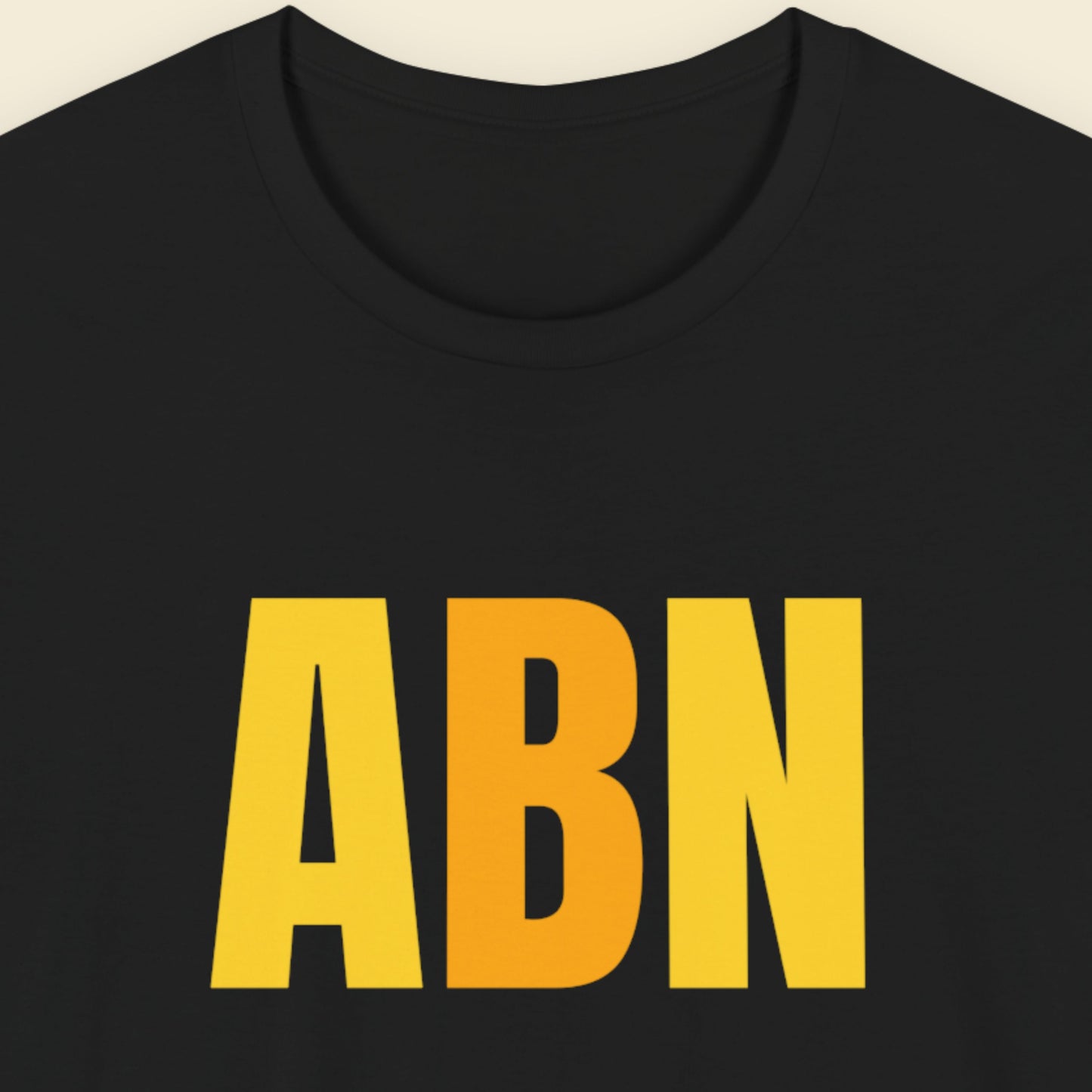 Black t-shirt with colorful text on a beige background.