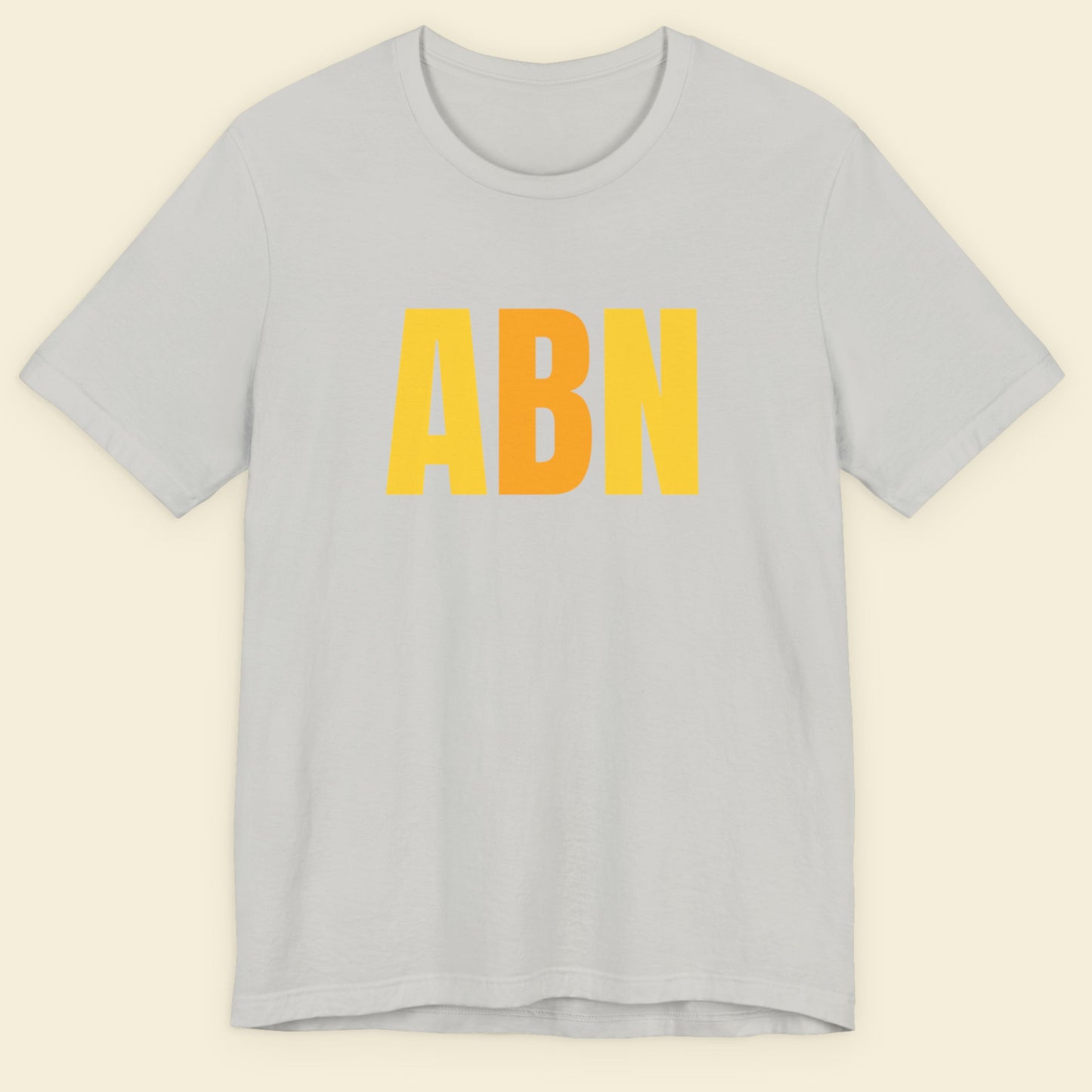Grey t-shirt with colorful text on a beige background.
