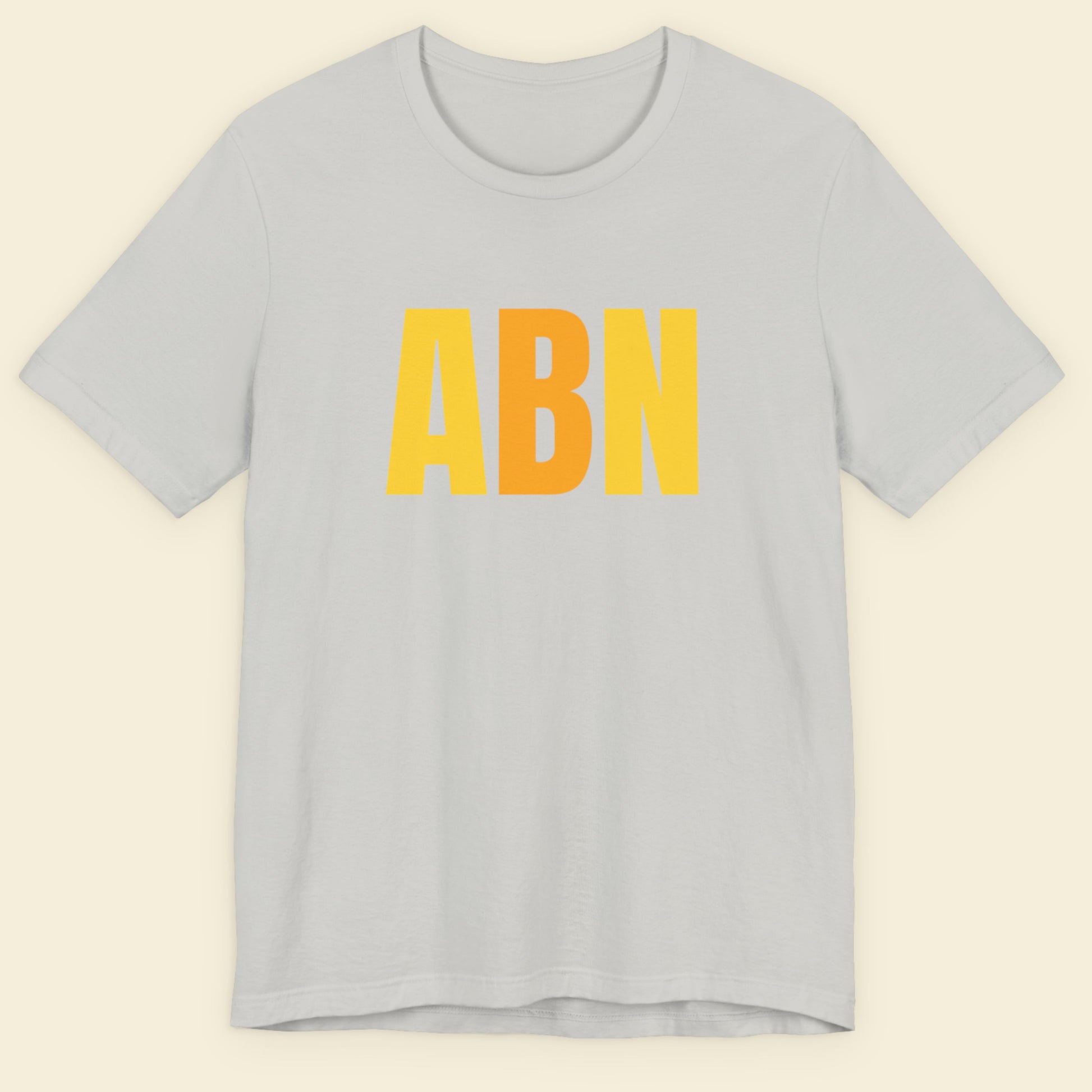 Grey t-shirt with colorful text on a beige background.