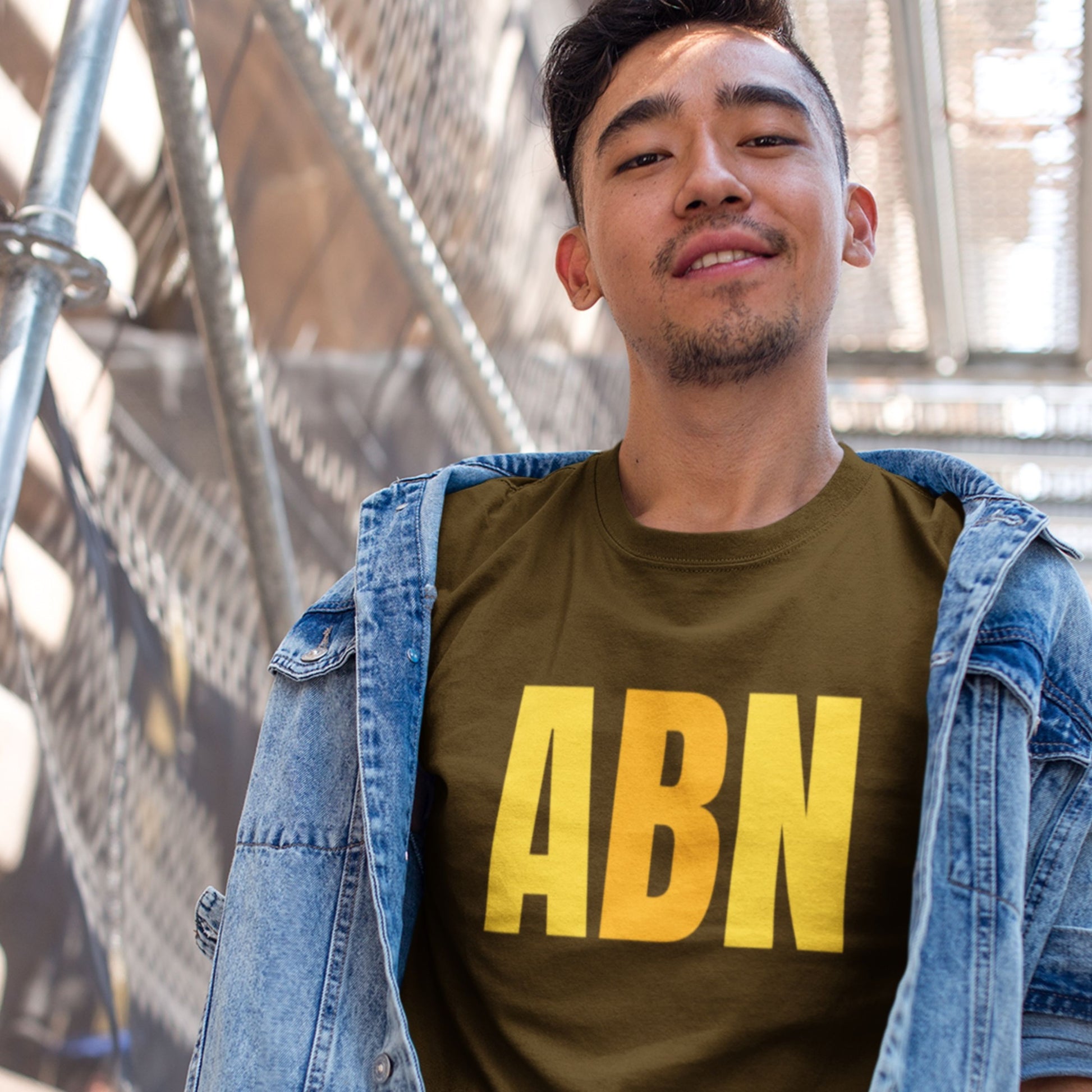 Brown t-shirt with colorful text on a ship worn by a man.