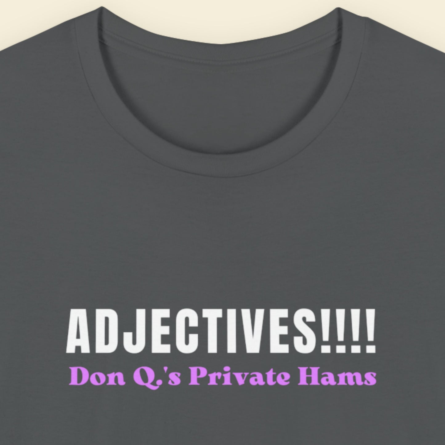 Grey t-shirt with humorous colorful text on a beige background.