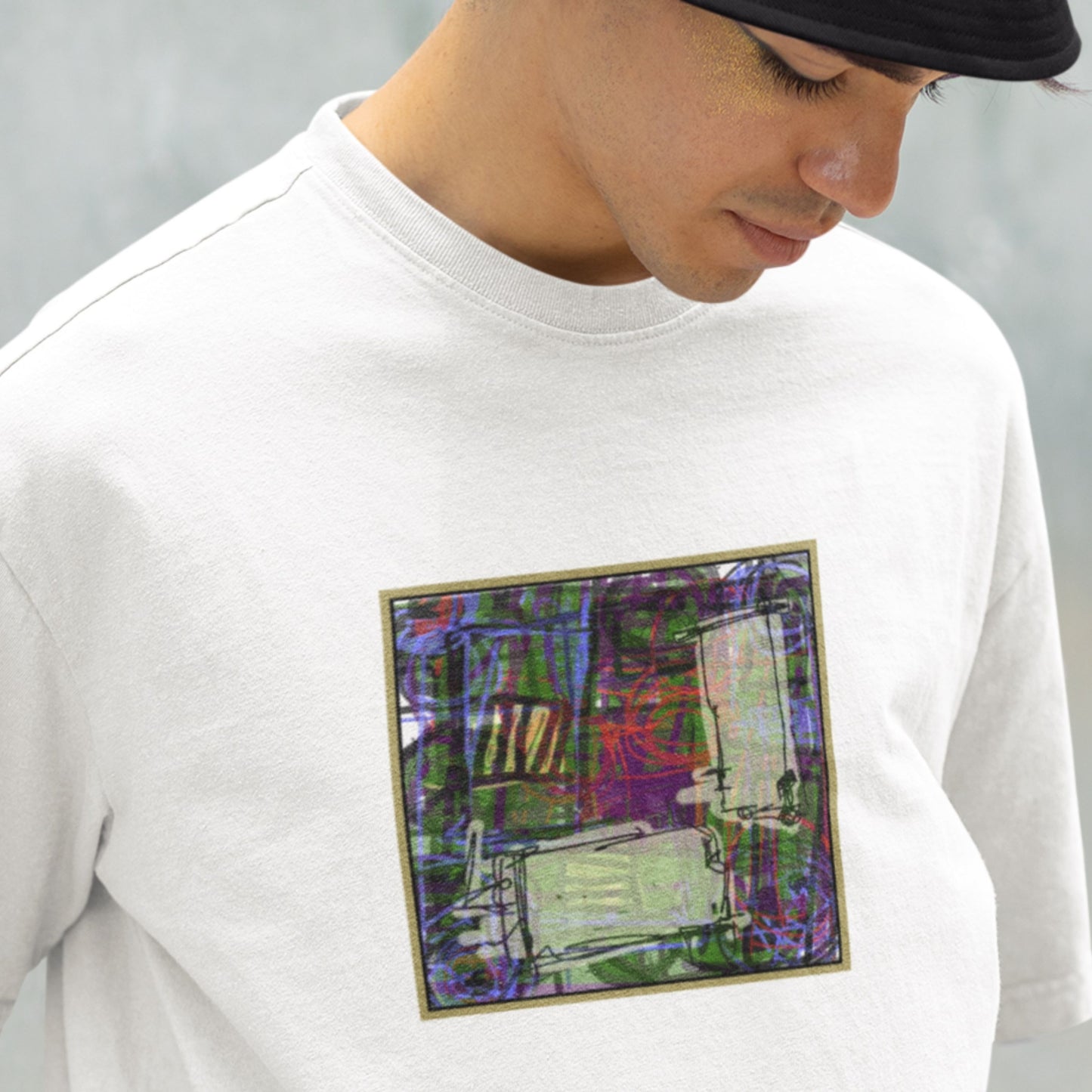 Person wearing a white t-shirt with a colorful abstract design on a gray background.