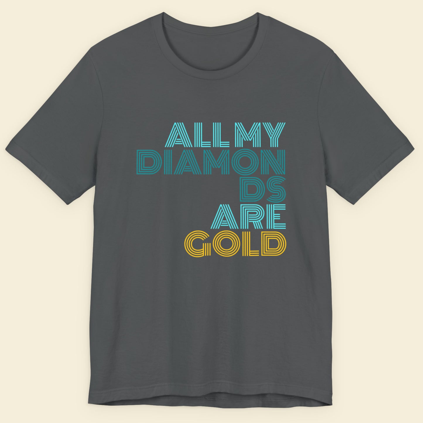 Gray t-shirt with 'All My Diamonds Are Gold' text in blue and yellow on a beige background.