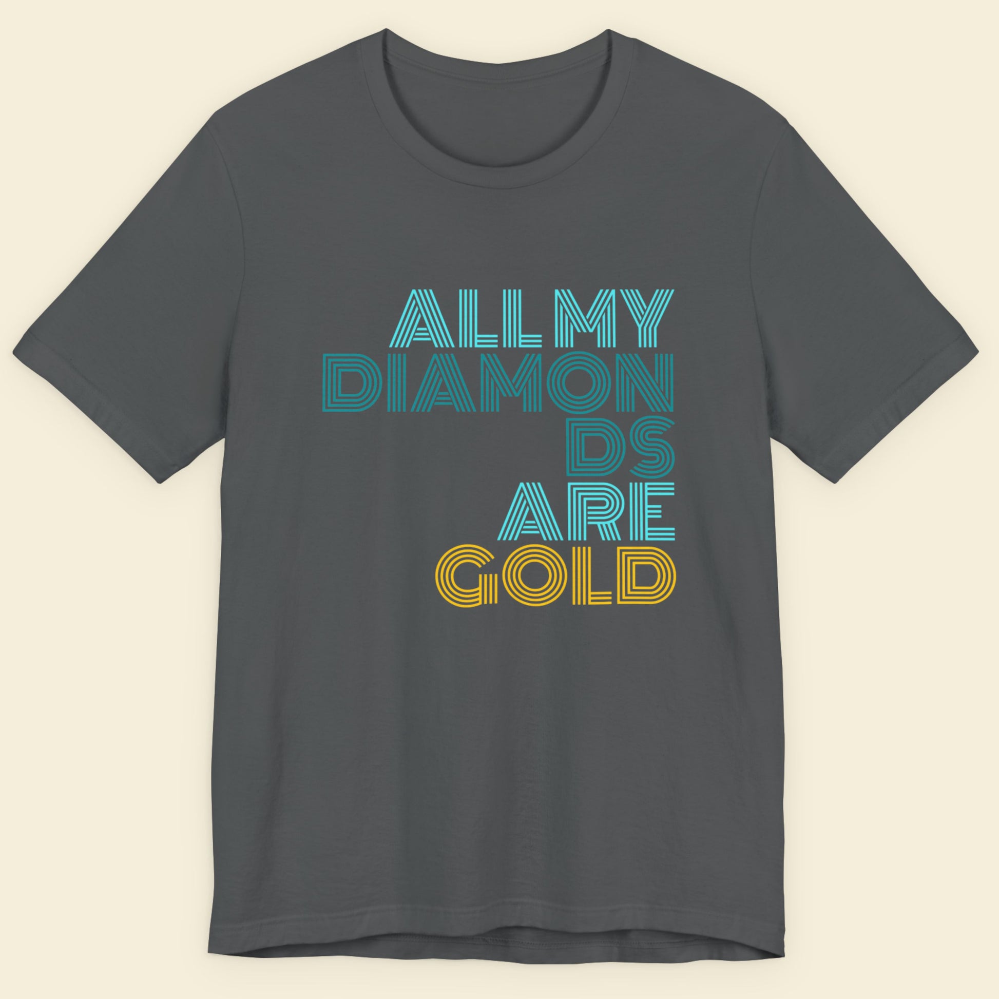 Gray t-shirt with 'All My Diamonds Are Gold' text in blue and yellow on a beige background.