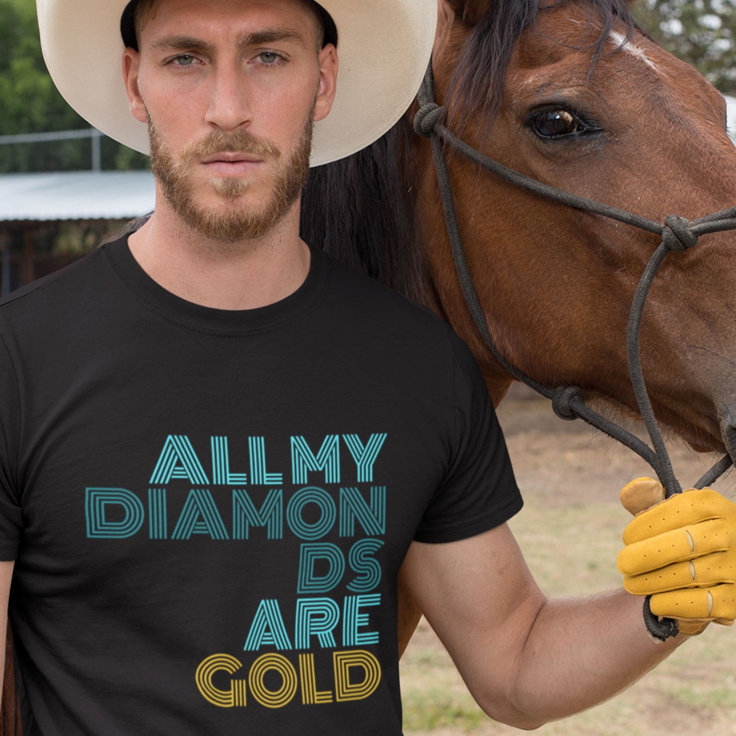 Man wearing a black t-shirt with 'All My Diamonds Are Gold' text, standing next to a horse.