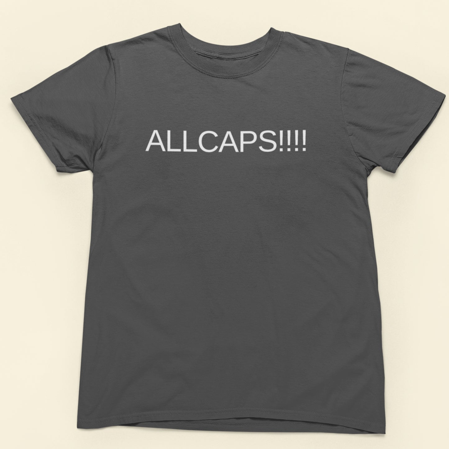 Gray t-shirt with 'ALLCAPS!!!!' text on a beige background
