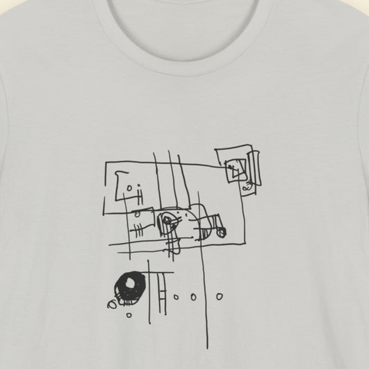 Grey t-shirt with an abstract line drawing on a beige background.