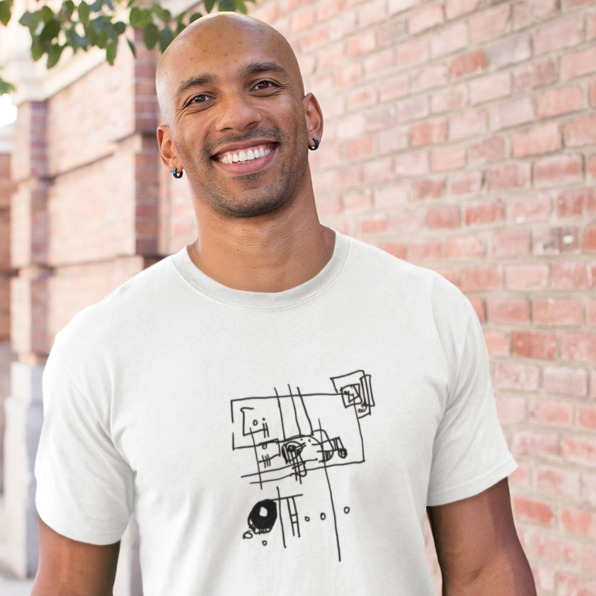 Smiling man wearing a white t-shirt with an abstract line drawing outside.