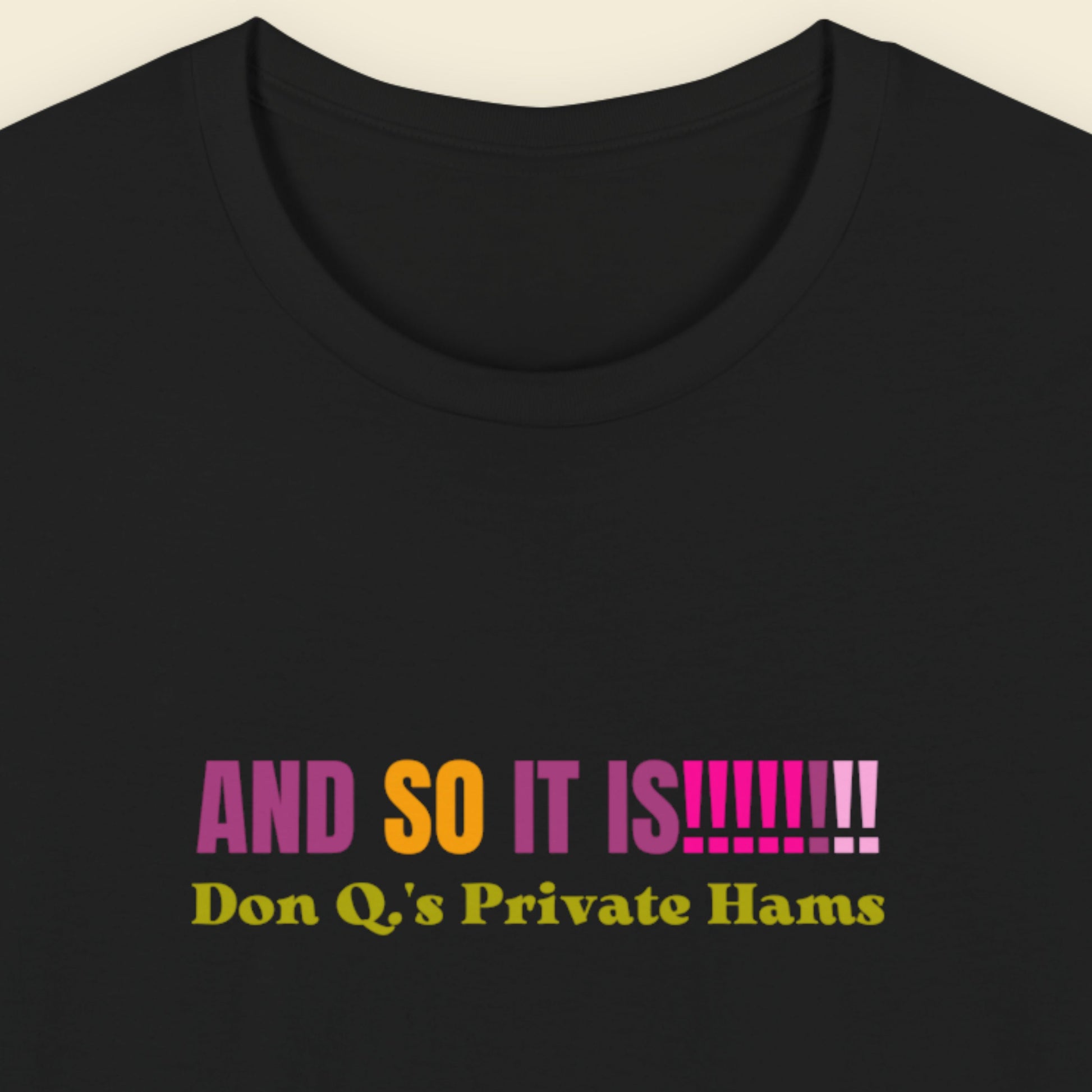 Black t-shirt with multicolored 'and so it is!!!!!!!!' text on a beige background.