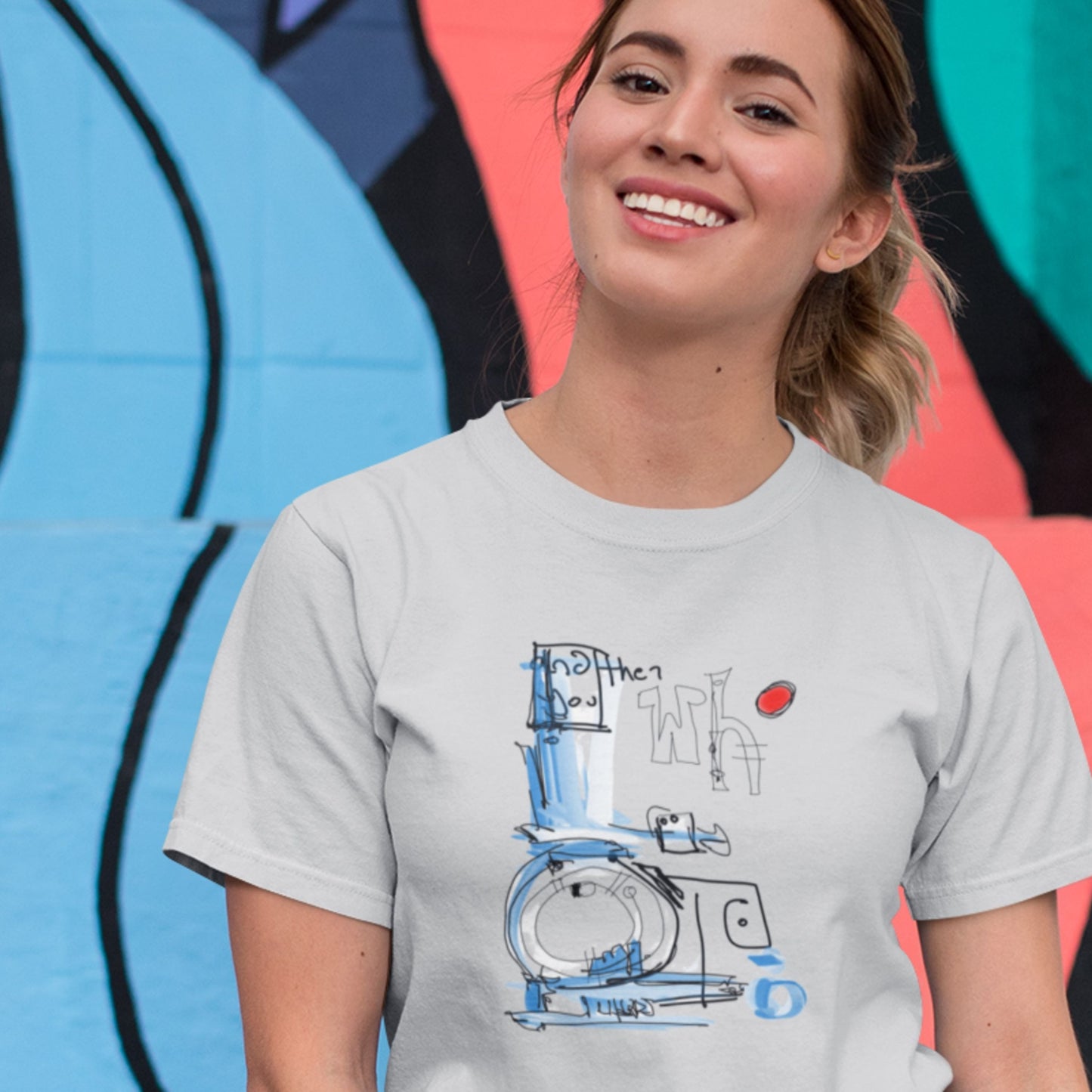 Smiling woman wearing a light grey t-shirt with a colorful abstract drawing on a colorful background.