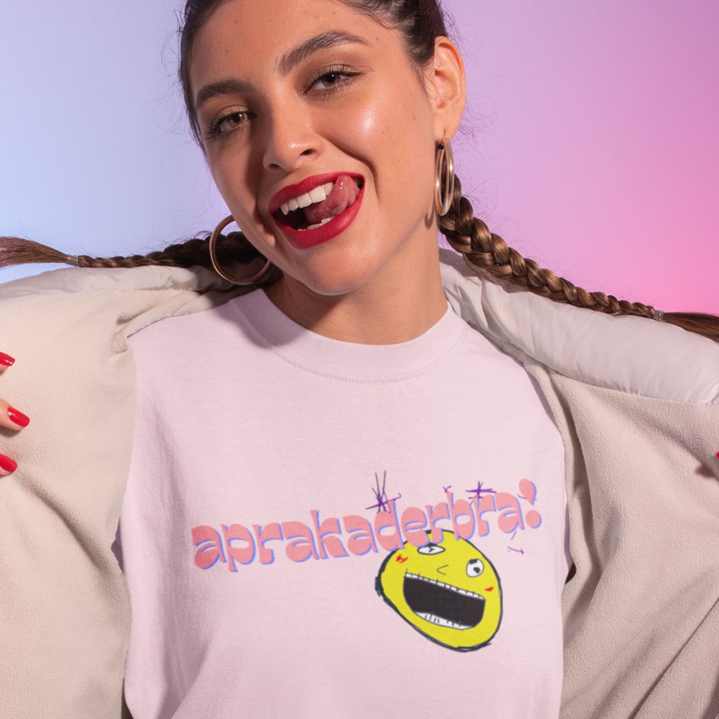 Woman wearing a light pink t-shirt with a colorful graphic design on a gradient background.