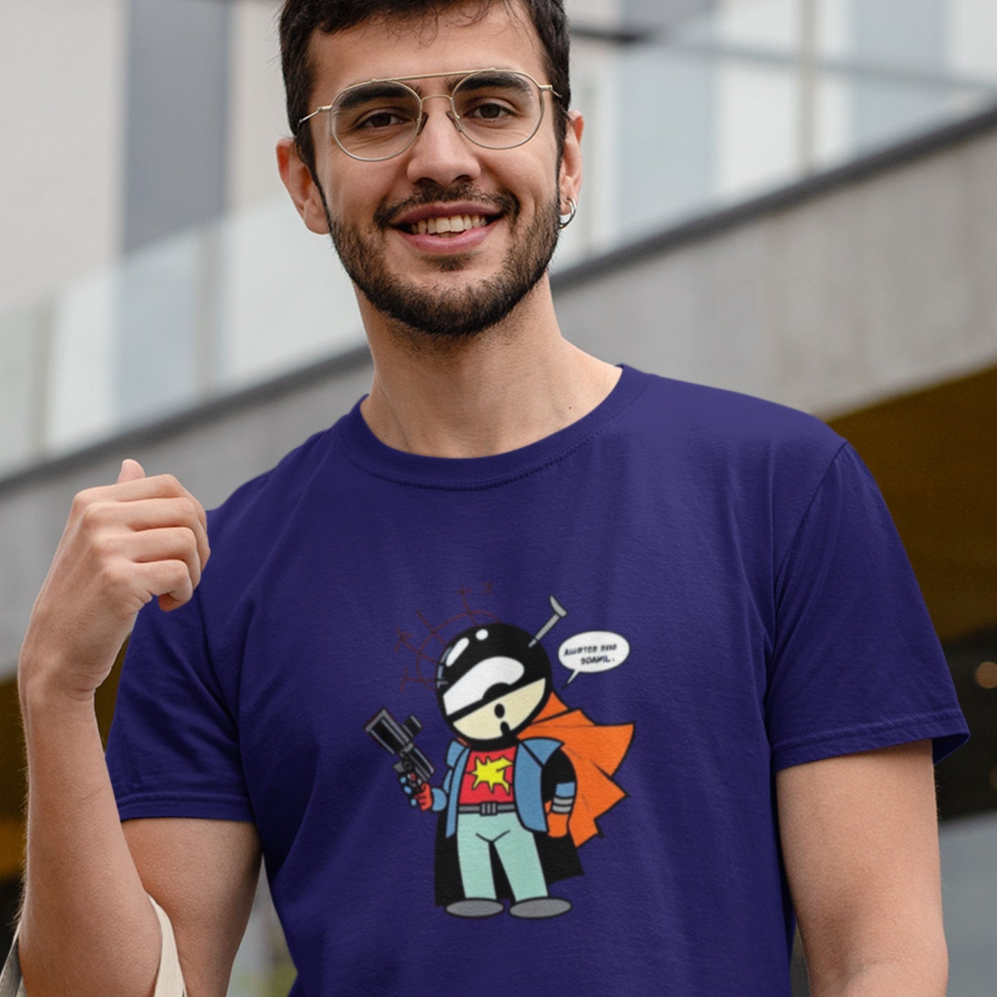 Glasses wearing man also wearing a navy blue shirt with a fun, colorful cartoon illustration in an office park.